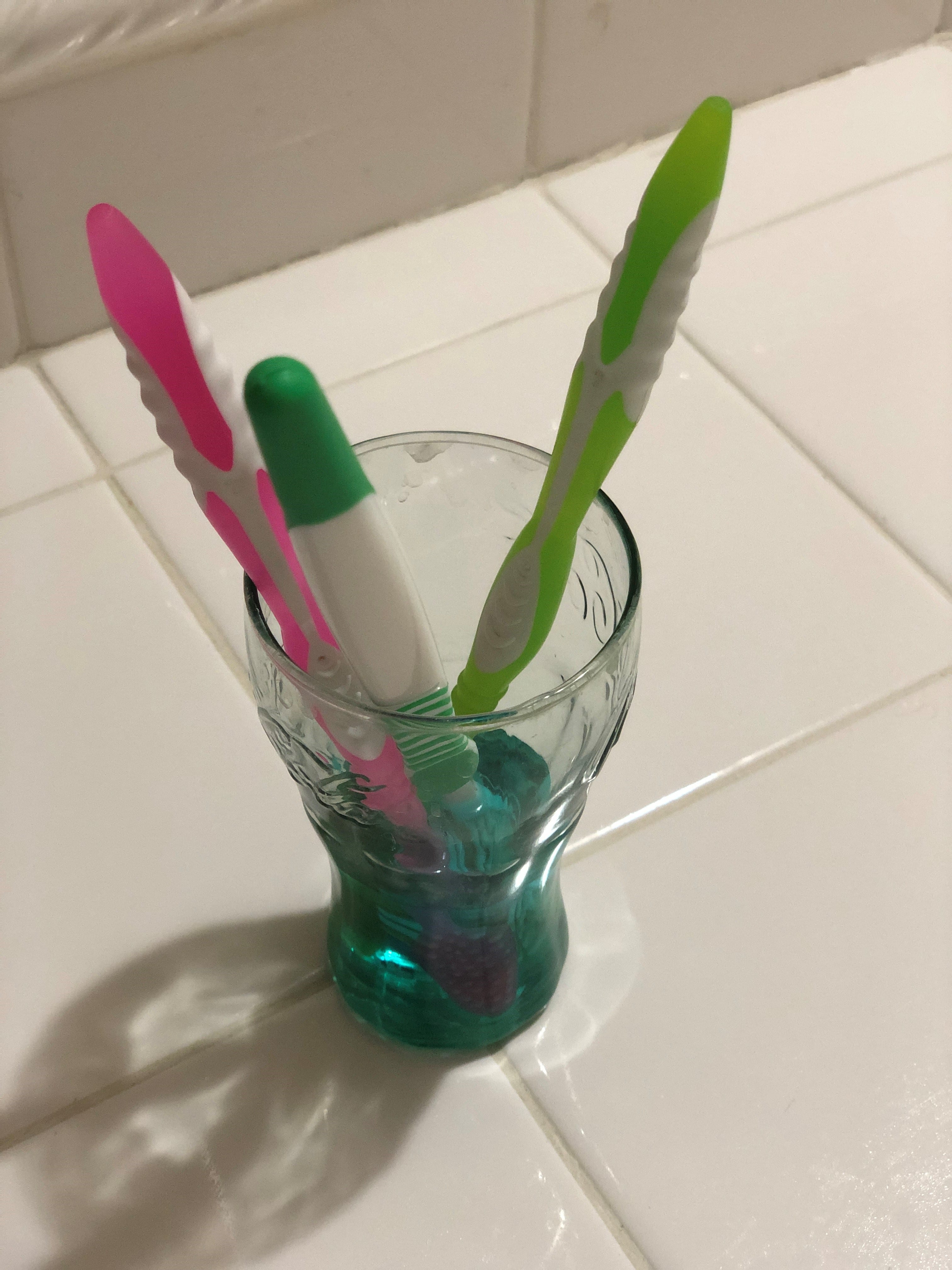 Pour mouthwash into a small narrow cup/glass and soak toothbrushes